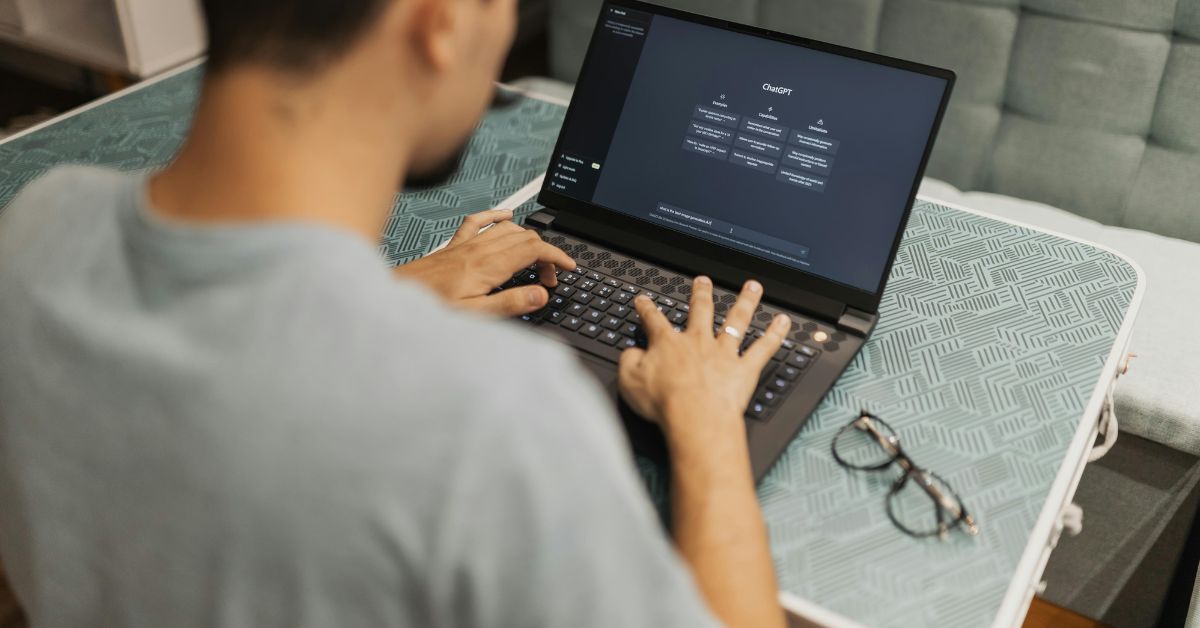 homem de camiseta cinza digitando no notebook, questionando-se se o chatgpt nos deixa menos inteligentes