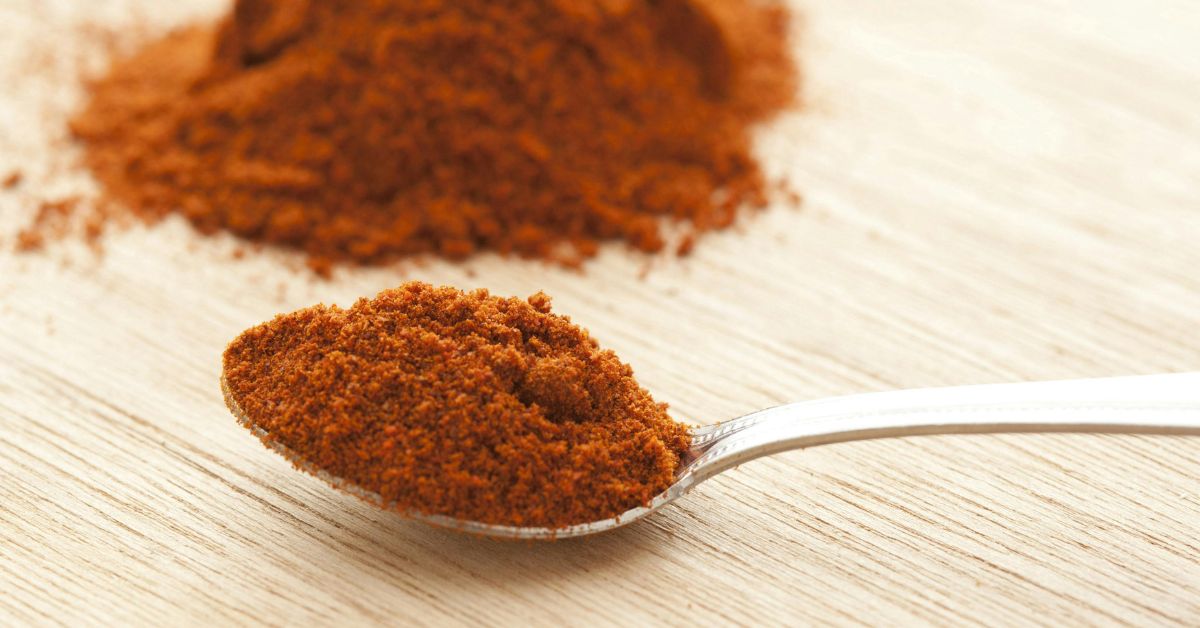 um punhado de canela em cima de uma mesa e em uma colher de sopa, prontos para soprar canela no dia 1